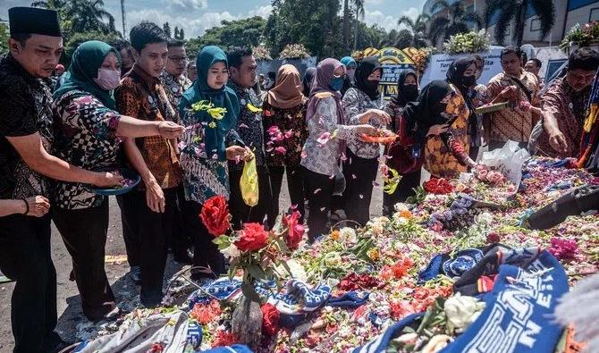 Des personnes rendant hommage aux victimes de la bousculade au stade Kanjuruhan à Malang, dans l'est de la province de Java, le 4 octobre 2022. (Photo, AFP)