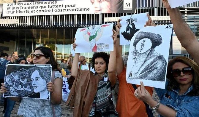 Des femmes manifestent avec des pancartes lors du dévoilement d'une banderole sur la façade de la mairie en soutien aux Iraniens luttant pour leur liberté et contre l'obscurantisme dans leur pays, à Montpellier, France, le 3 octobre 2022. (Photo, AFP)