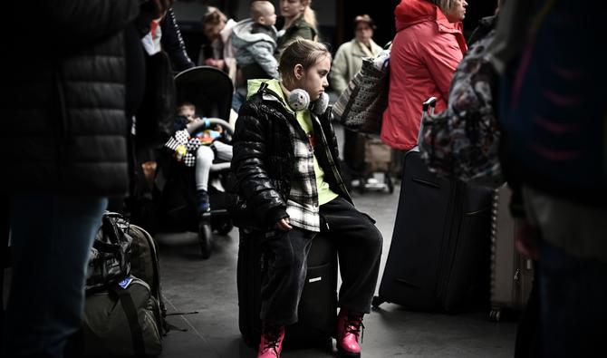 Un jeune réfugiée ukrainienne est assise sur une valise après avoir débarqué de Moldavie à l'aéroport international de Bordeaux à Mérignac, le 21 avril 2022. (Photo, AFP)