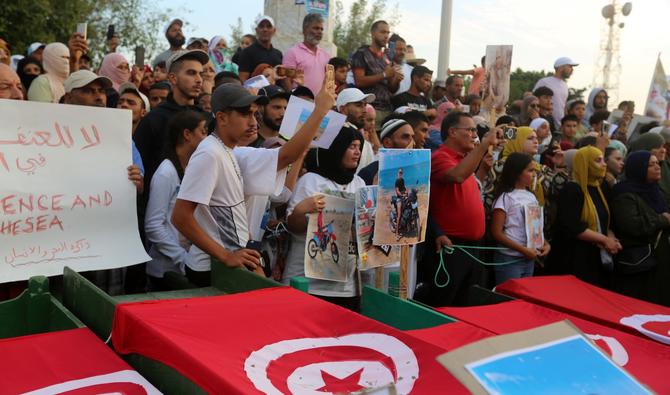 Des Tunisiens entourent de faux cercueils et tiennent des photos de victimes alors qu'ils participent à une manifestation, exigeant des réponses sur le sort de 12 personnes qui ont disparu en mer en septembre de cette année, dans la ville côtière de Zarzis, dans le sud-est de la Tunisie, le 4 novembre 2022 (Photo, AFP)