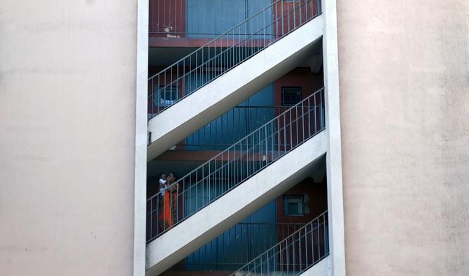 Sur cette photo d'archive prise le 30 août 2021, une femme et un enfant se tiennent debout dans une cage d'escalier du quartier «Les rosiers» à Marseille, dans le sud de la France. (Photo, AFP)