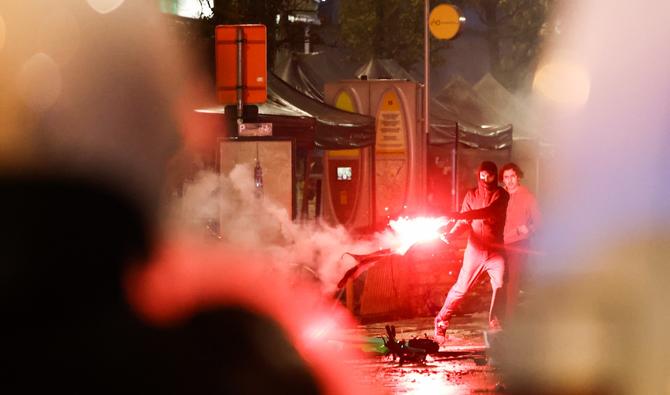 Un manifestant tient une fusée rouge en marge de la retransmission en direct du match de football du groupe F de la Coupe du monde Qatar 2022 entre la Belgique et le Maroc, à Bruxelles, le 27 novembre 2022. (Photo, AFP)