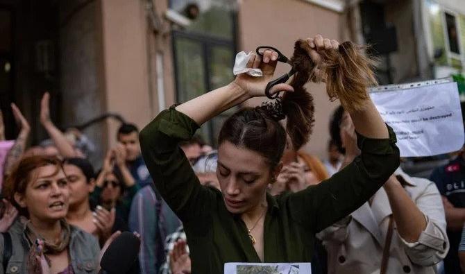 Nasibe Samsaei, femme iranienne qui habite en Turquie, coupe sa queue de cheval lors d'une manifestation devant le consulat iranien à Istanbul. (Dossier/AFP)