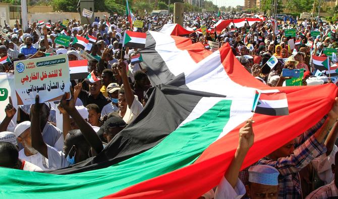 Des manifestants soudanais déploient un drapeau national géant alors qu'ils défilent devant le siège de l'ONU, le 3 décembre 2022. (Photo, AFP)