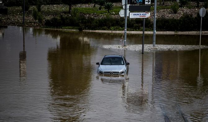 Une voiture abandonnée au milieu d'une rue inondée, à Frielas, en périphérie de Lisbonne, le 13 décembre 2022. (Photo, AFP)
