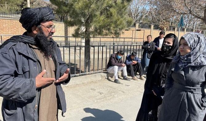 Un membre taliban s'entretient avec des étudiantes à l'extérieur de l'Université d'éducation de Kaboul. (Fichier/Reuters)