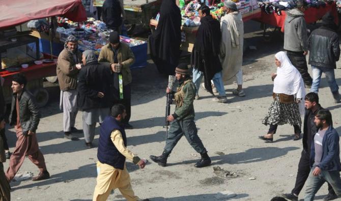 Un agent de la police (au centre) parcourt un bazar animé à Kaboul, en Afghanistan. (AP)