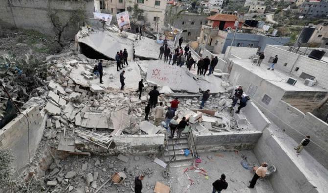 Des personnes examinent les décombres d’une maison démolie par des soldats israéliens dans le village de Kafr Dan, à Jénine, en Cisjordanie occupée, le 2 janvier 2023. (AFP)