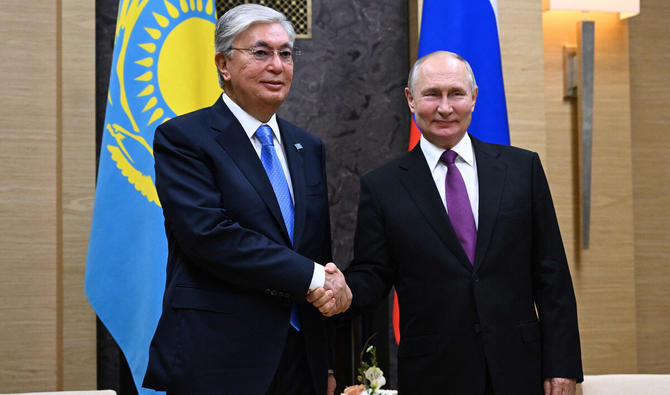 Sur cette photo de pool distribuée par l'agence Sputnik, le président russe Vladimir Poutine (à droite) serre la main du président du Kazakhstan Kassym-Jomart Tokayev (à gauche) lors de leur rencontre à Novo-Ogaryovo, le 7 octobre 2023. (Photo Pavel BEDNYAKOV / AFP)