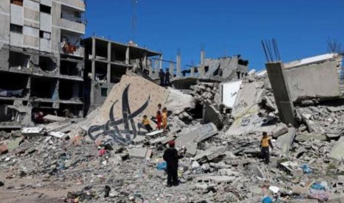 Des enfants se tiennent à côté d'un mur tombé, portant une peinture murale, au sein des décombres d'un bâtiment détruit par un bombardement israélien à Rafah, le 22 février 2024, alors que les batailles entre Israël et le Hamas se poursuivent. (Photo, AFP)